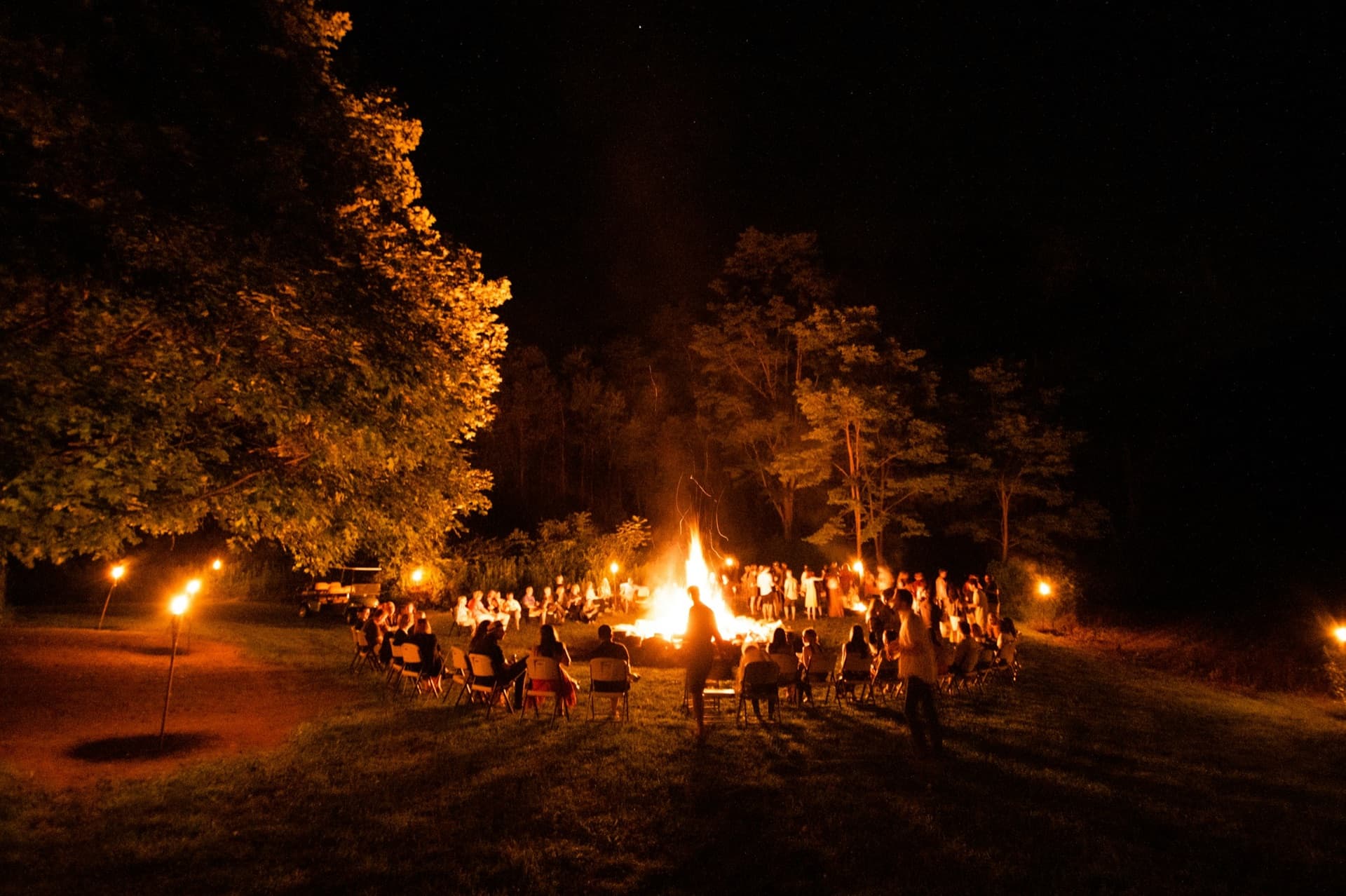 Groep jongeren rond een kampvuur in het bos